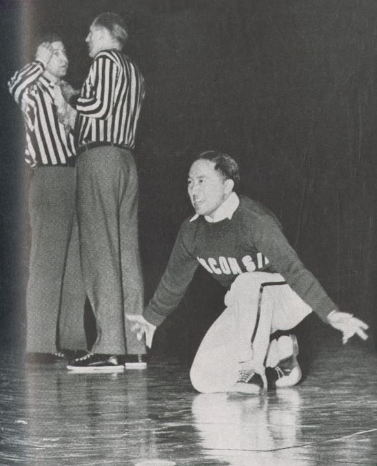Toru Iura Toru Iura performing during his time as a UW Cheerleader. He is kneeling on one knee in front of two referees.