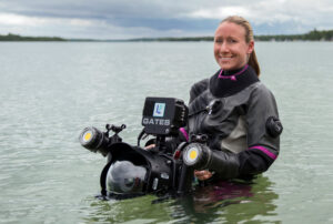 Photographer in water with a large waterproof camera