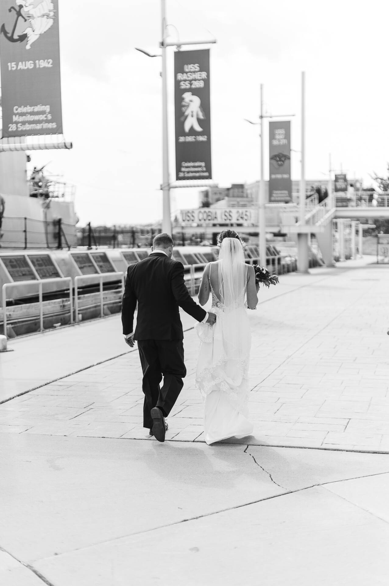 A bride and groom walking next to the sub.